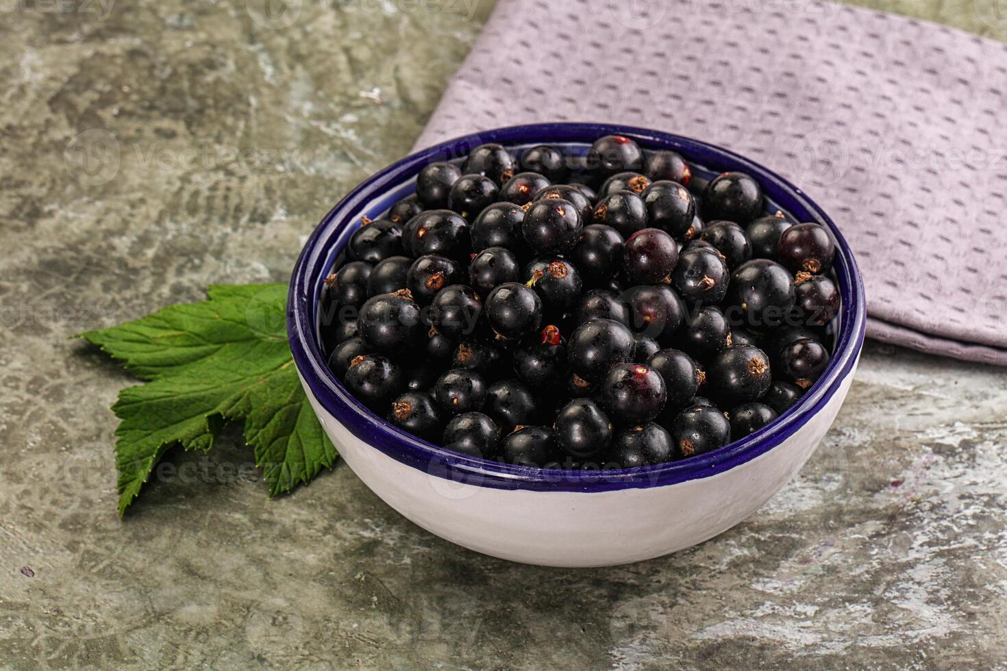 Black currant in a bowl on a table photo
