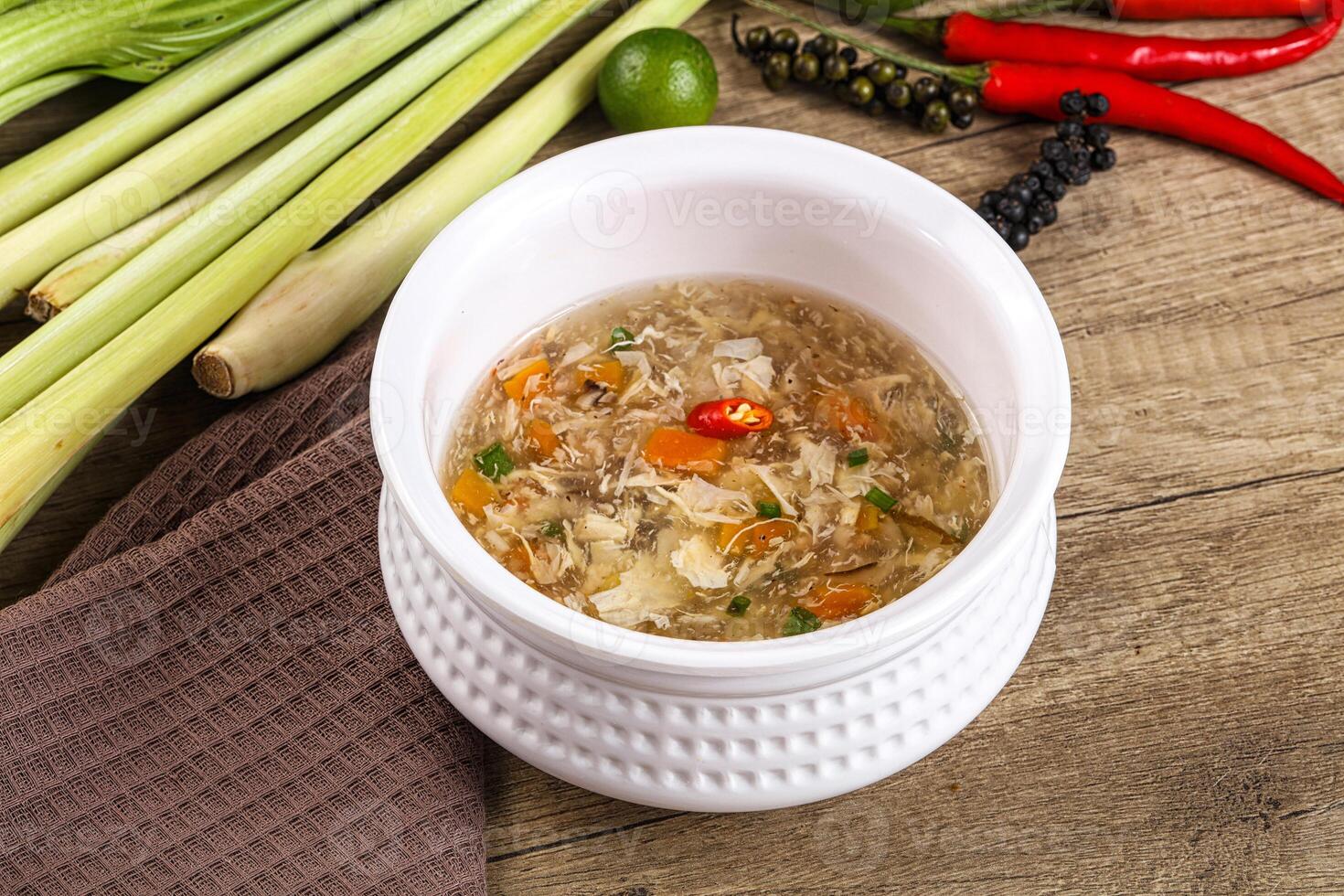 A bowl of soup with vegetables and herbs photo
