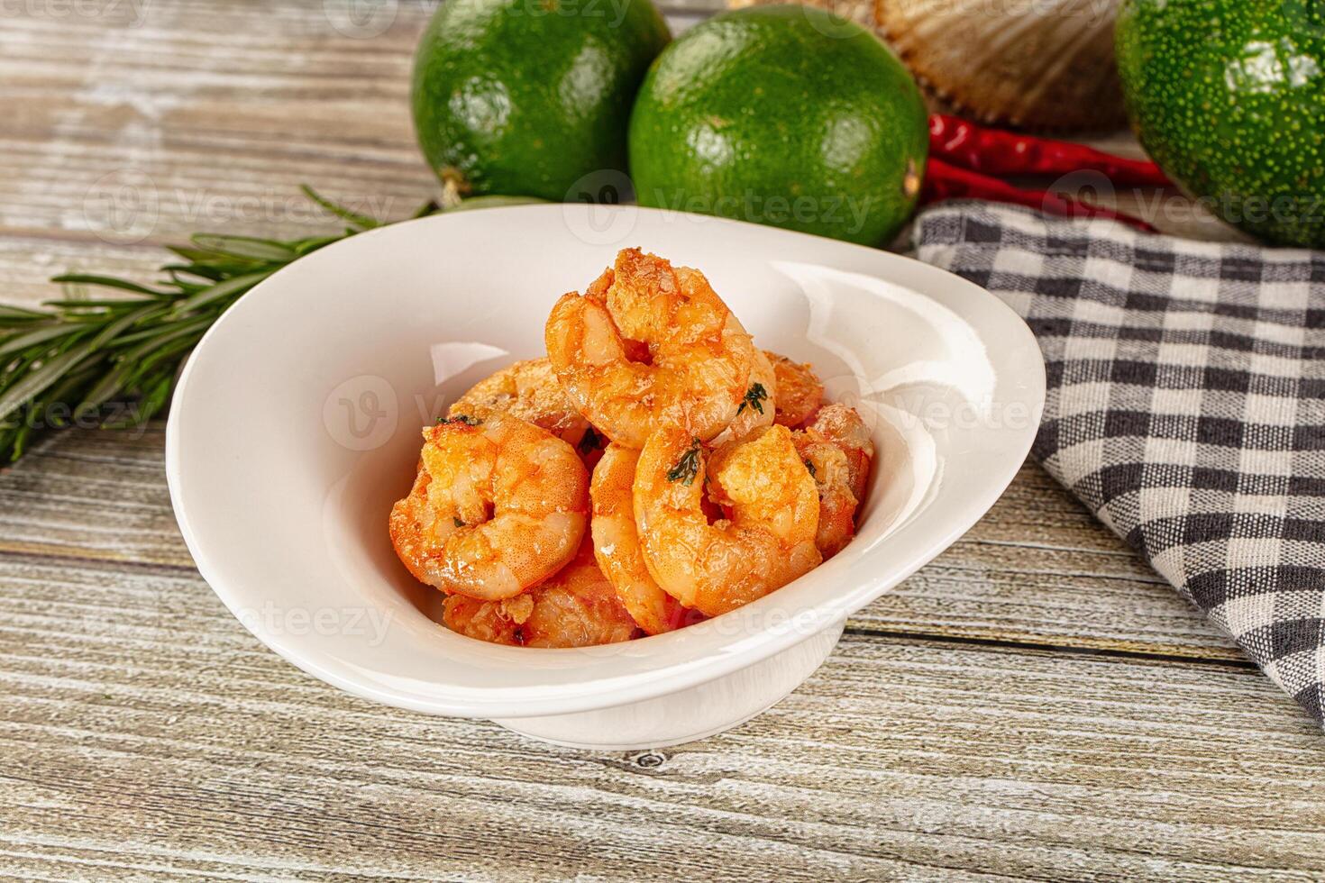 A bowl of shrimp on a table next to some other food photo