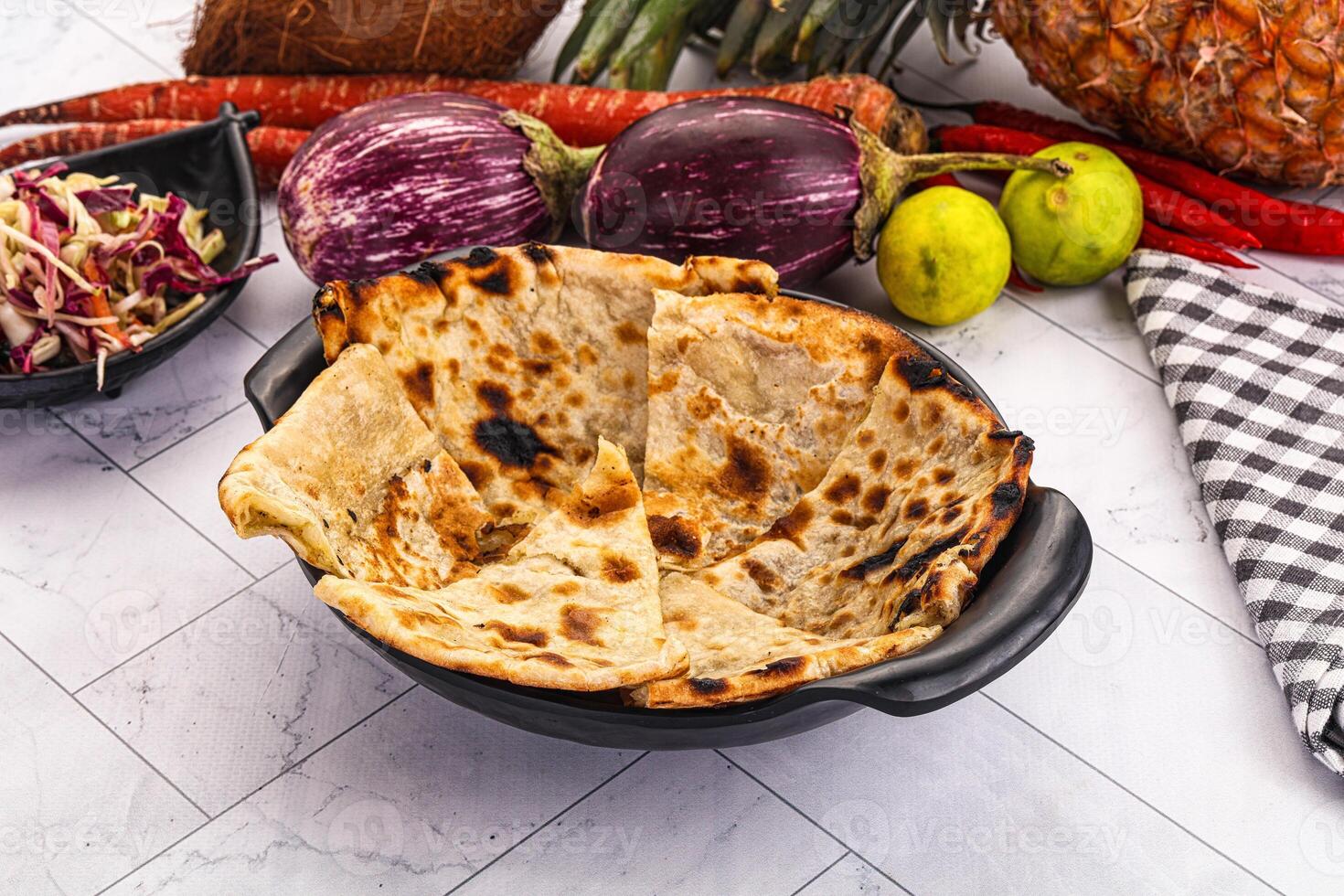 A bowl of food with a tortilla, vegetables and a pineapple photo