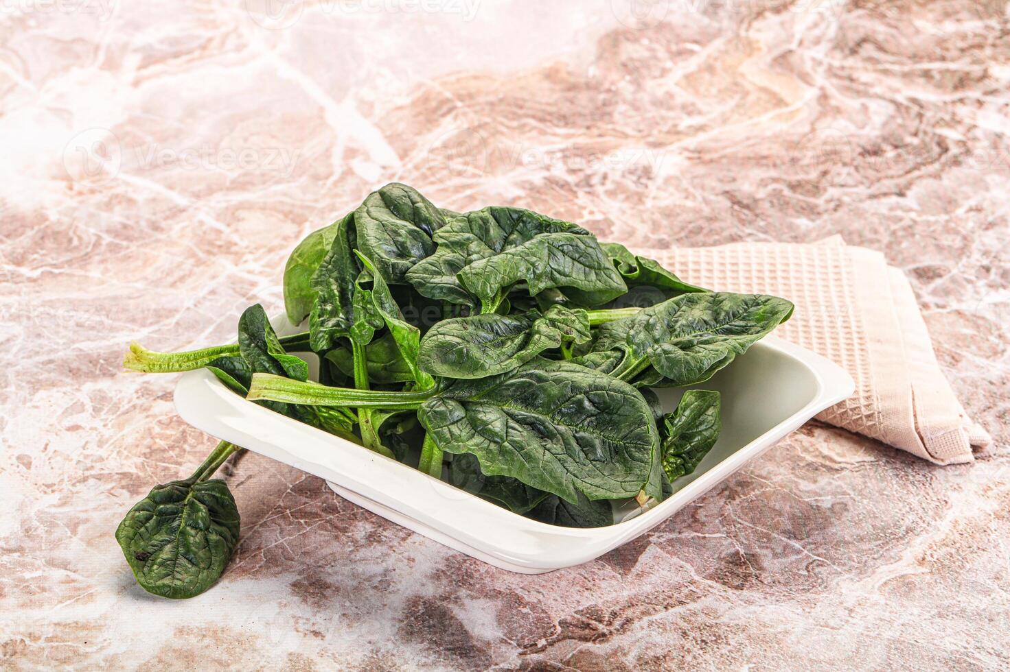 A bowl of spinach on a marble counter photo