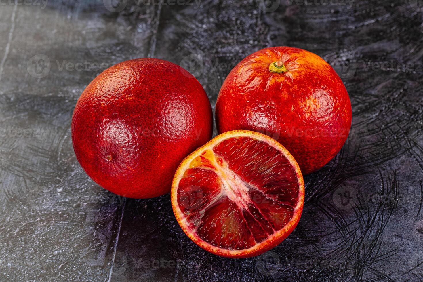 Two blood oranges are sitting on a table photo