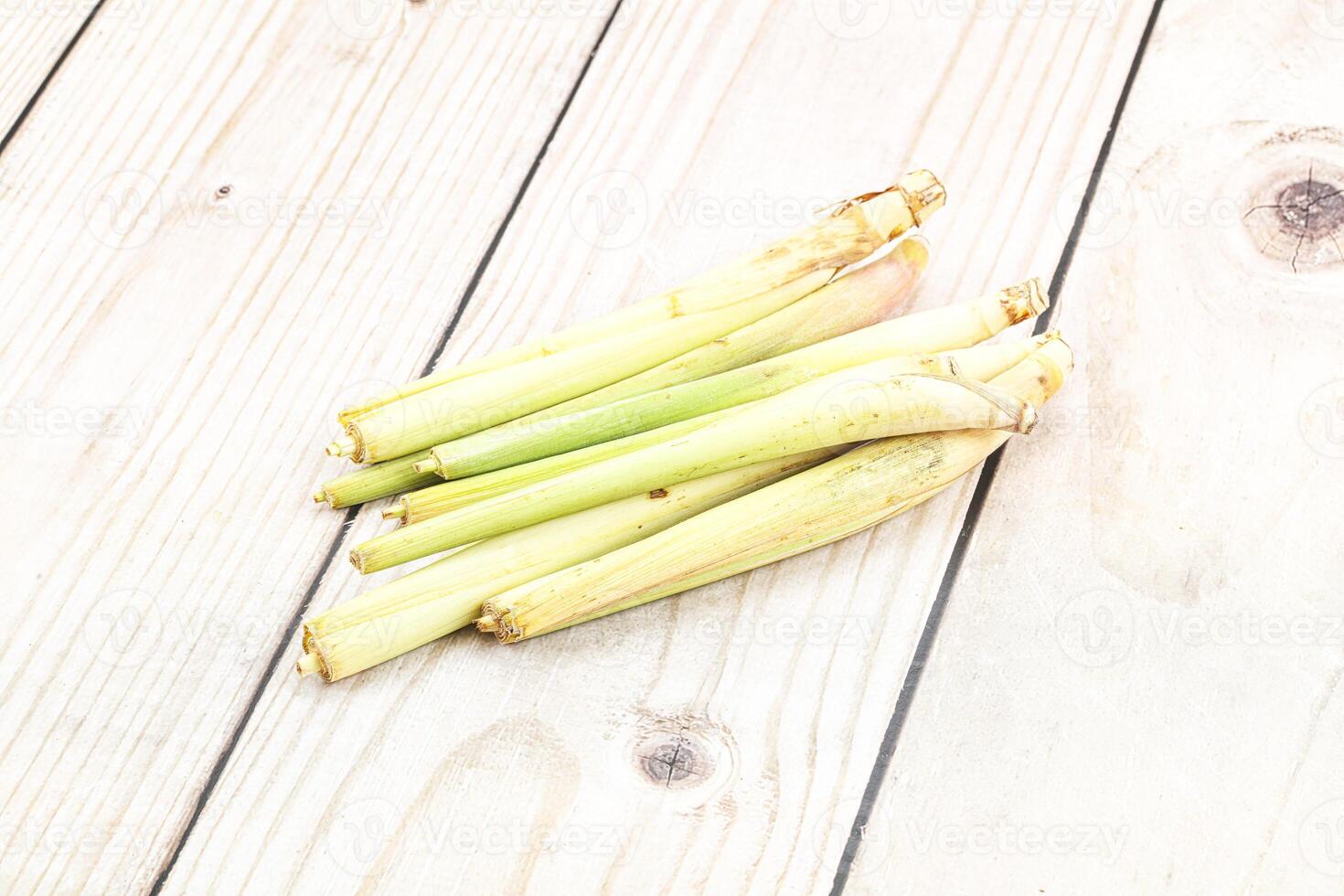 A bunch of green stalks on a wooden table photo