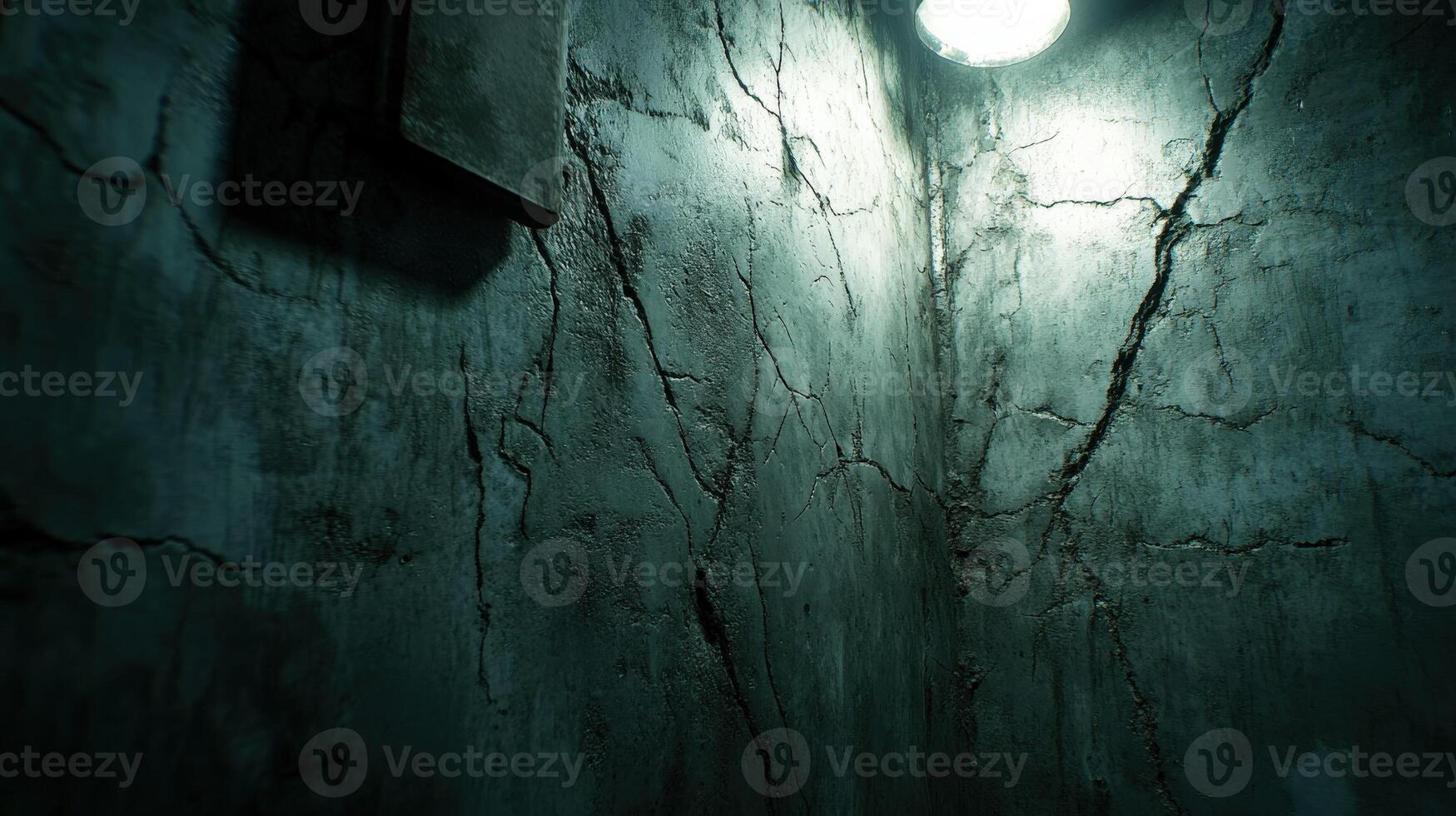 Dimly lit corner of an aged and cracked concrete wall photo