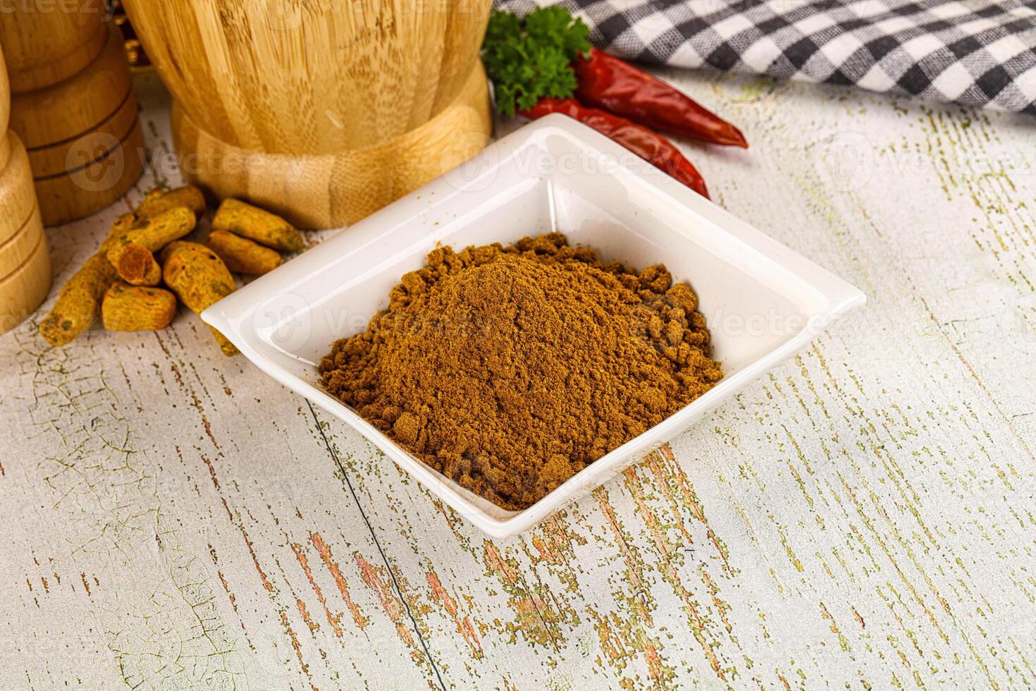 A bowl of spices and spices on a wooden table photo