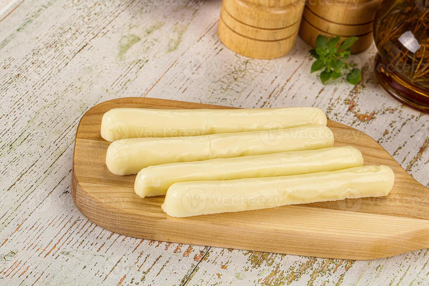 A wooden cutting board with four pieces of cheese on it photo