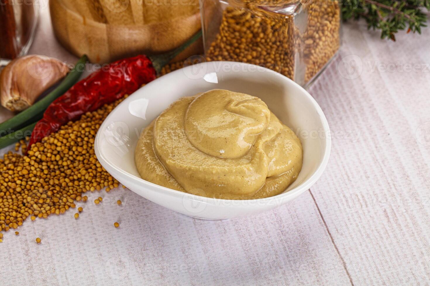 A bowl of mustard and spices on a table photo