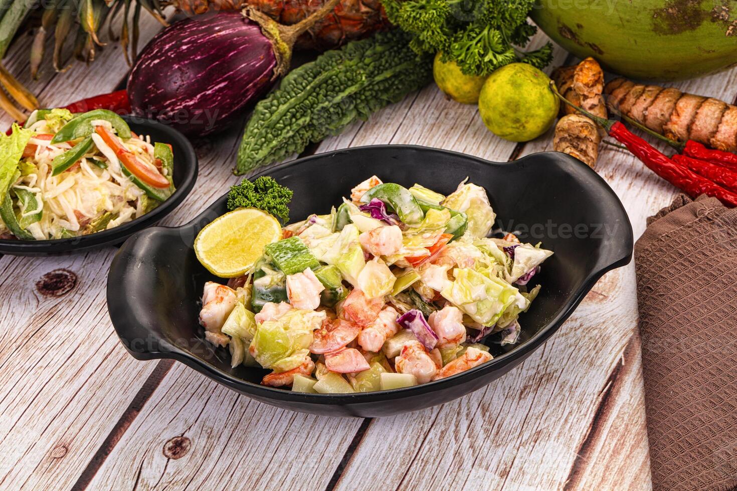 A table with two bowls of food and a plate of vegetables photo