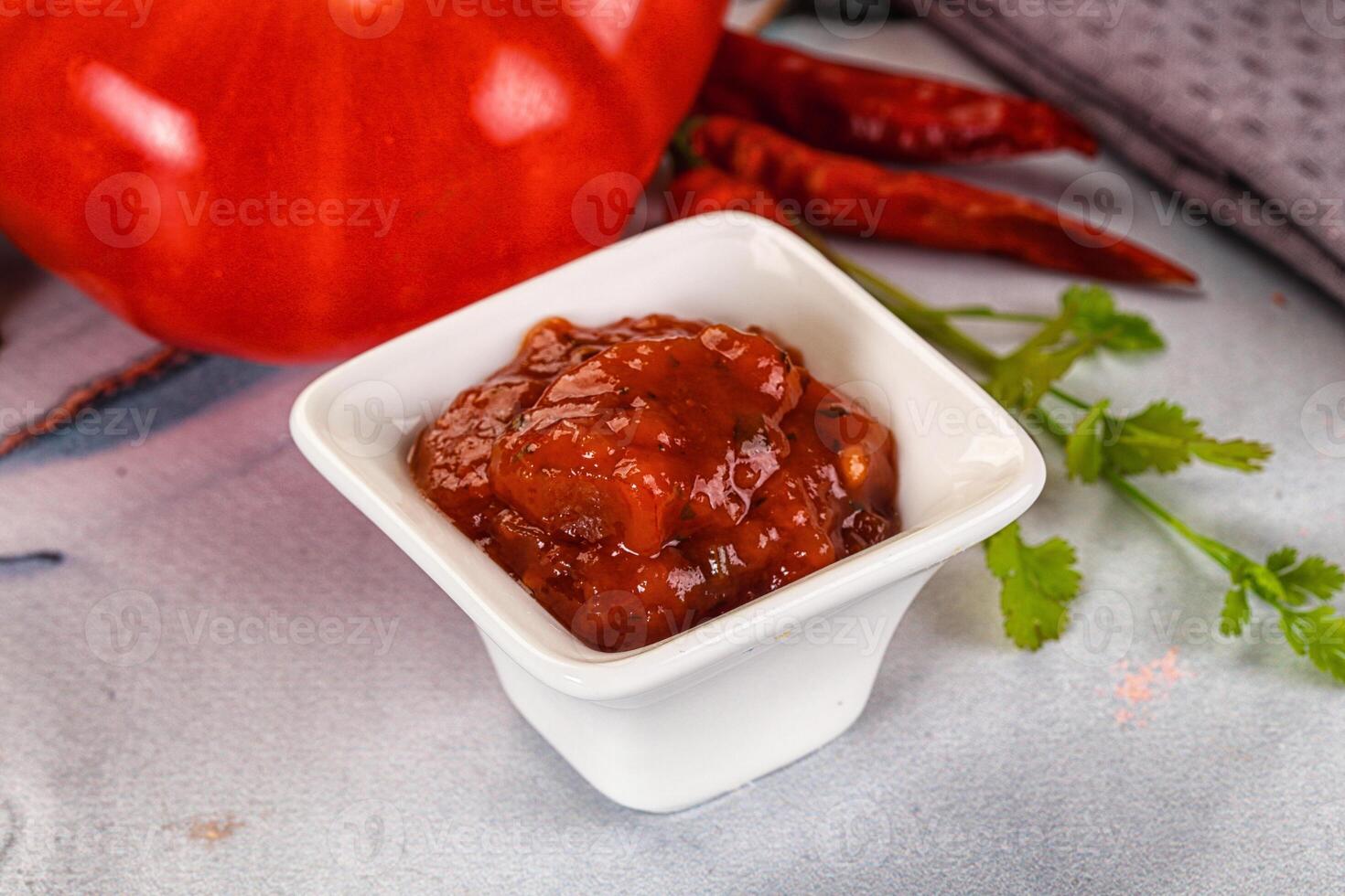 A white bowl with a tomato and some spices photo