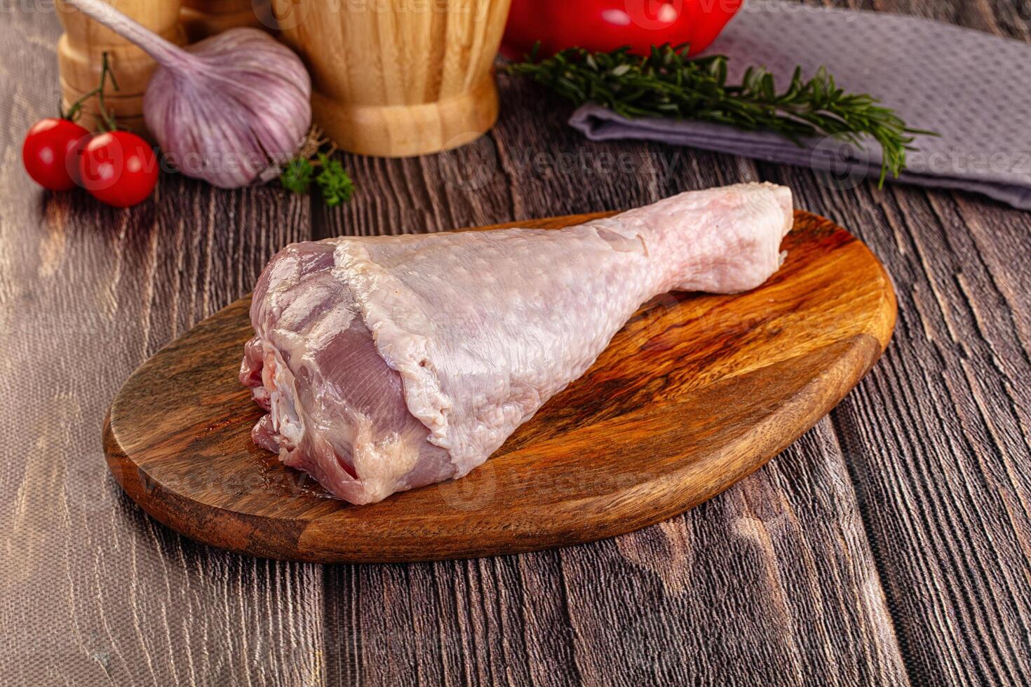 Raw meat on a wooden cutting board with vegetables and herbs photo
