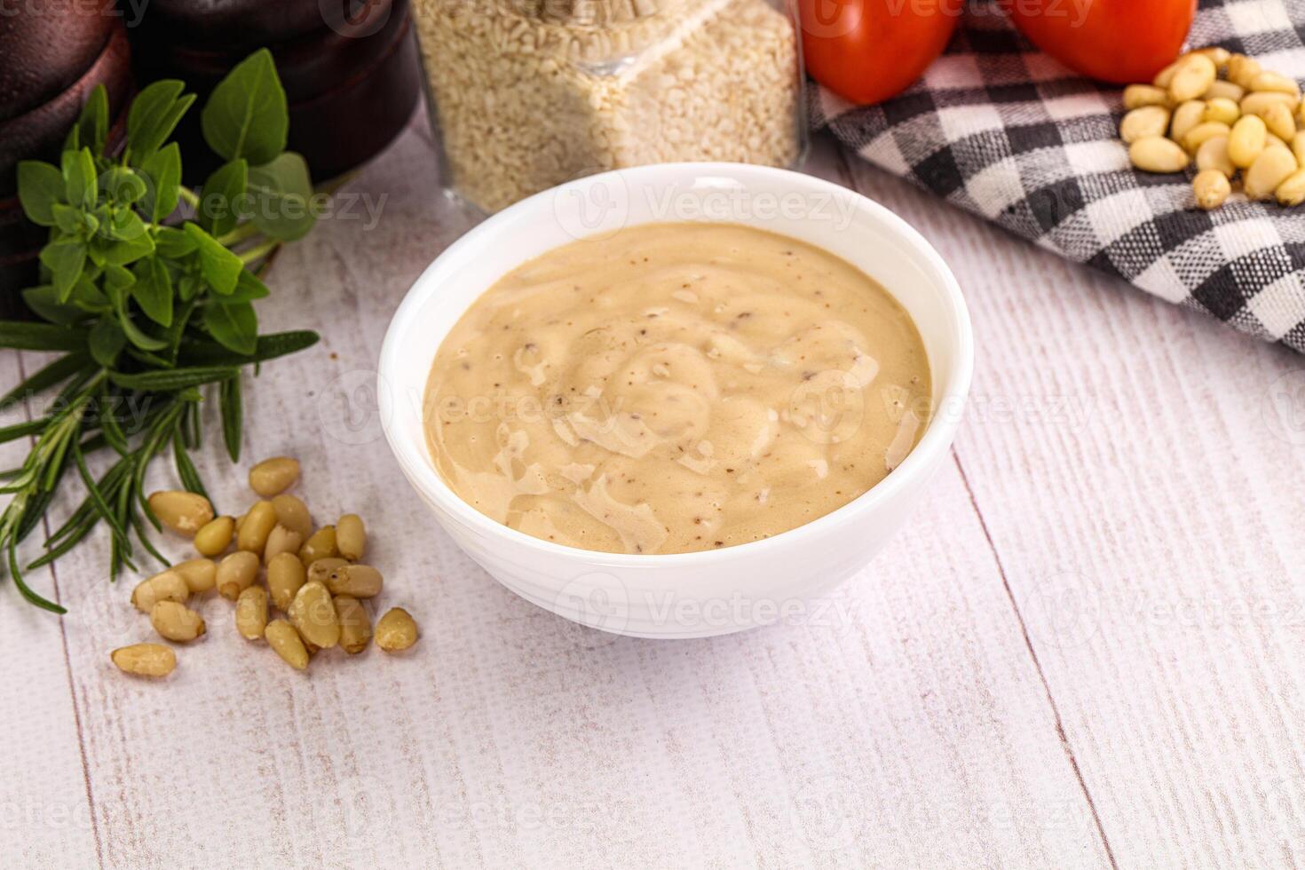 A bowl of peanut butter sauce on a wooden table photo