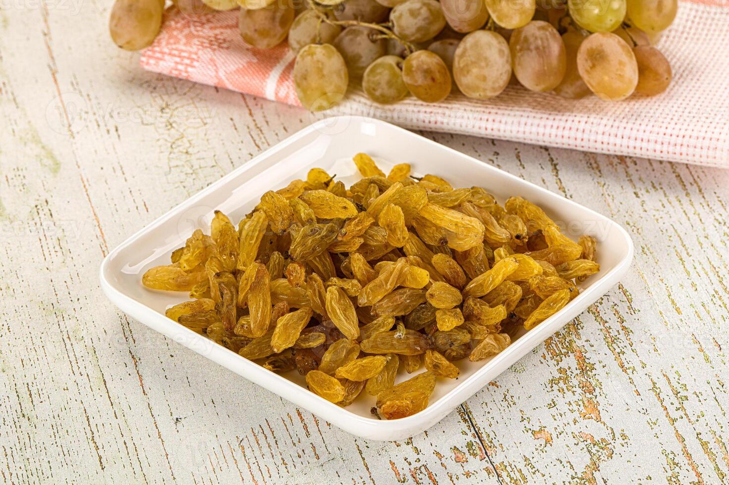 A bowl of raisins and a bowl of grapes photo