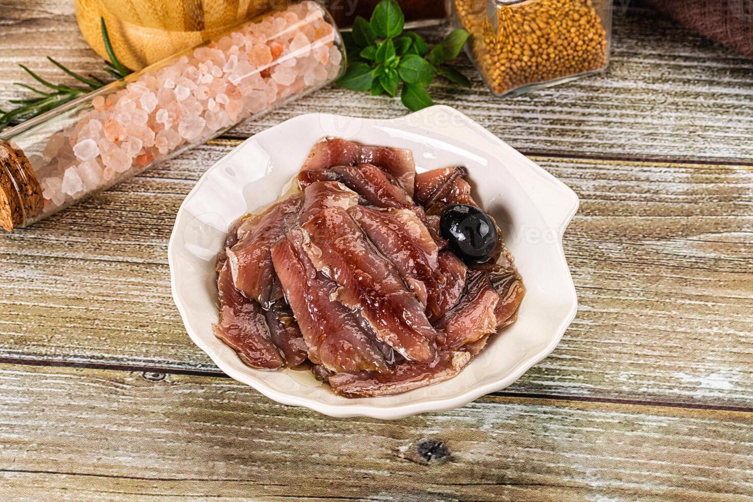 A bowl of meat and spices on a wooden table photo