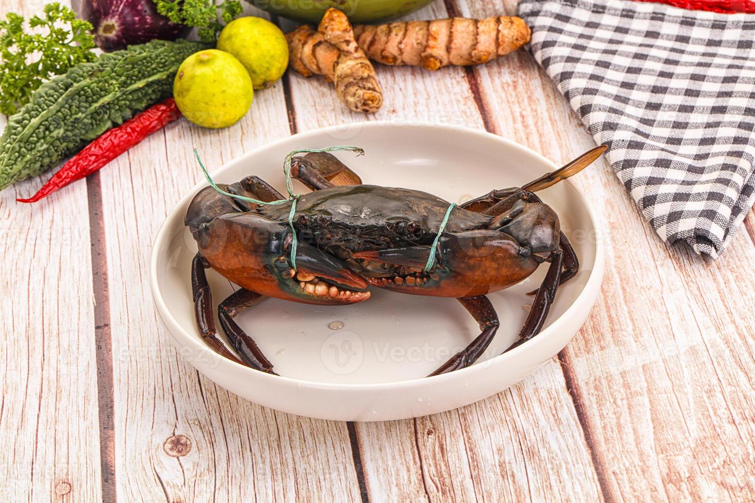 A crab sitting in a bowl with other vegetables photo