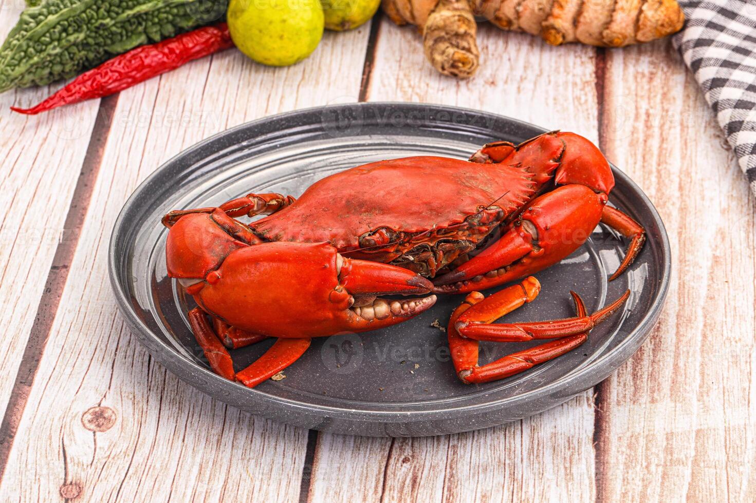 A plate with a crab on it and some other vegetables photo