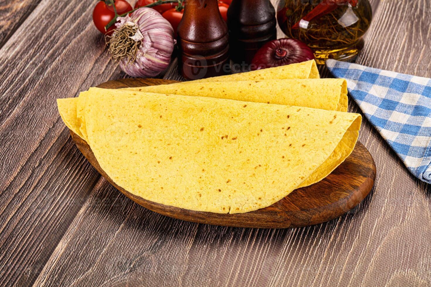 Three tortillas on a wooden cutting board photo