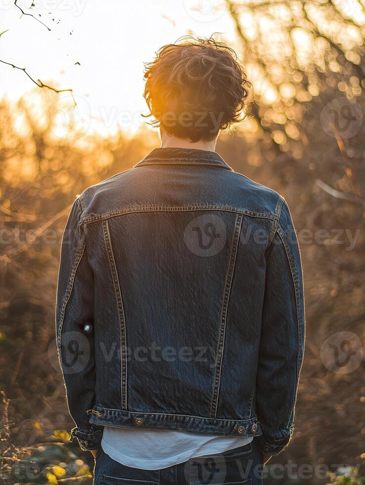 Young man enjoying a sunset in nature by the forest photo