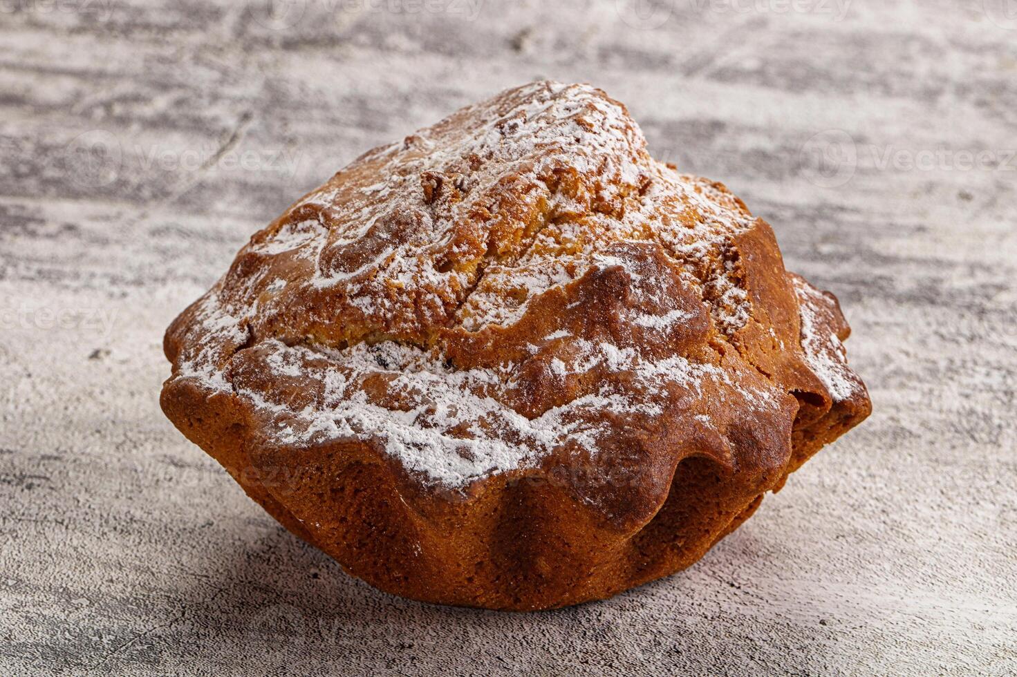 A muffin with powdered sugar on top photo