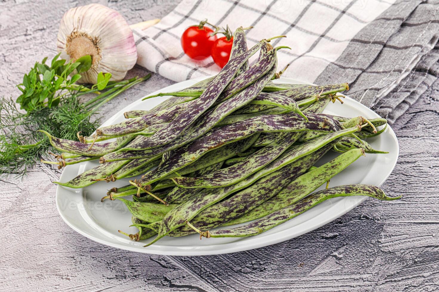A plate of beans and vegetables on a table photo
