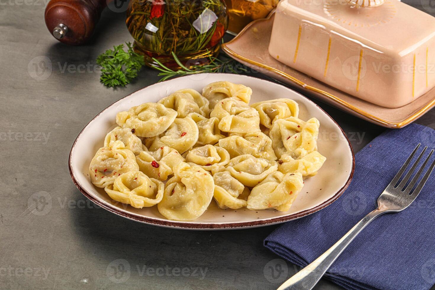 A plate of pasta with a fork and knife on a table photo