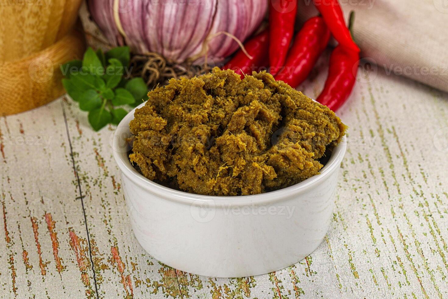 A bowl of spices and a pepper on a table photo