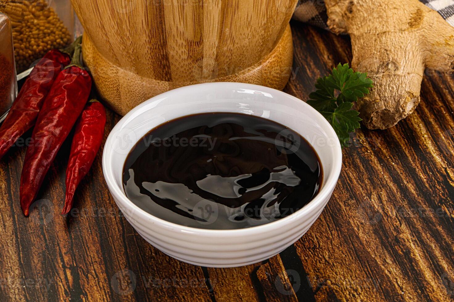 A bowl of black liquid next to a bowl of chili peppers photo