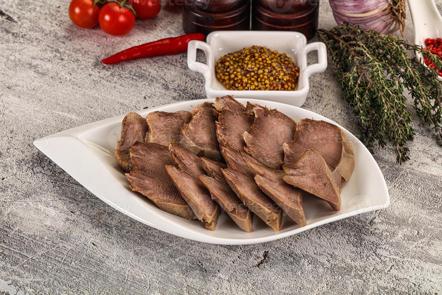 A plate of meat on a table with other ingredients photo