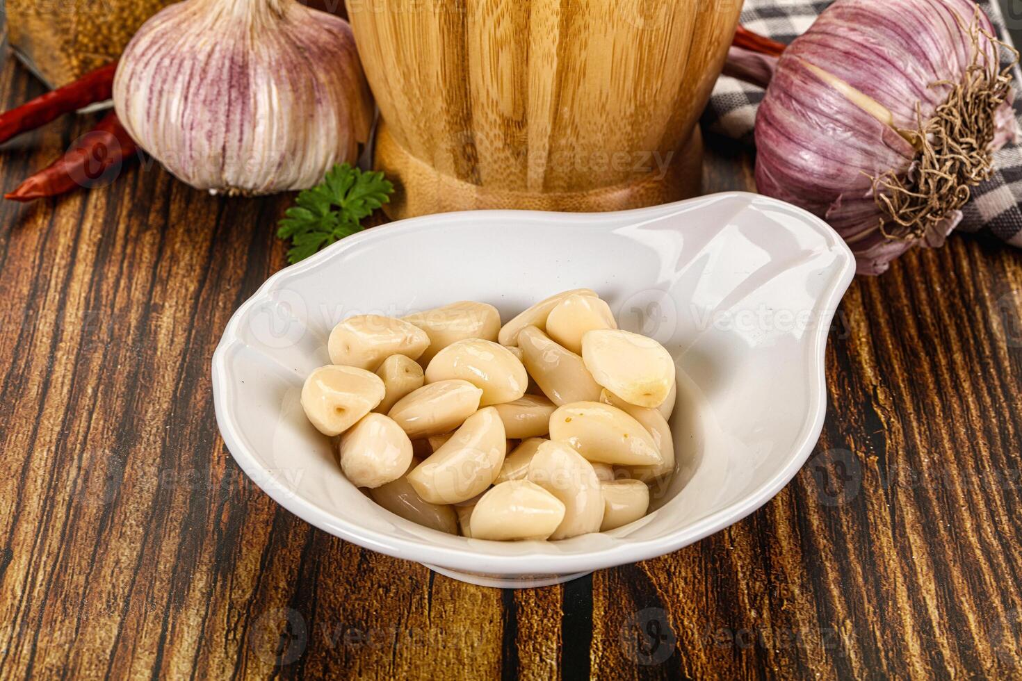 Garlic cloves in a bowl on a wooden table photo