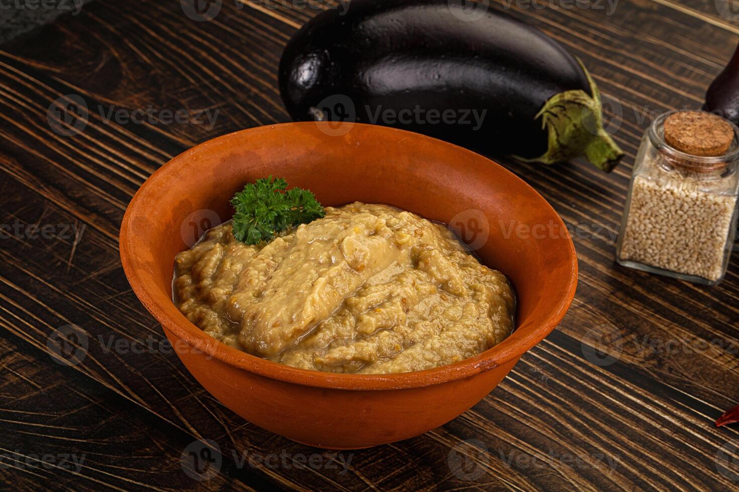 A bowl of eggplant dip with a spoon and a bowl of rice photo