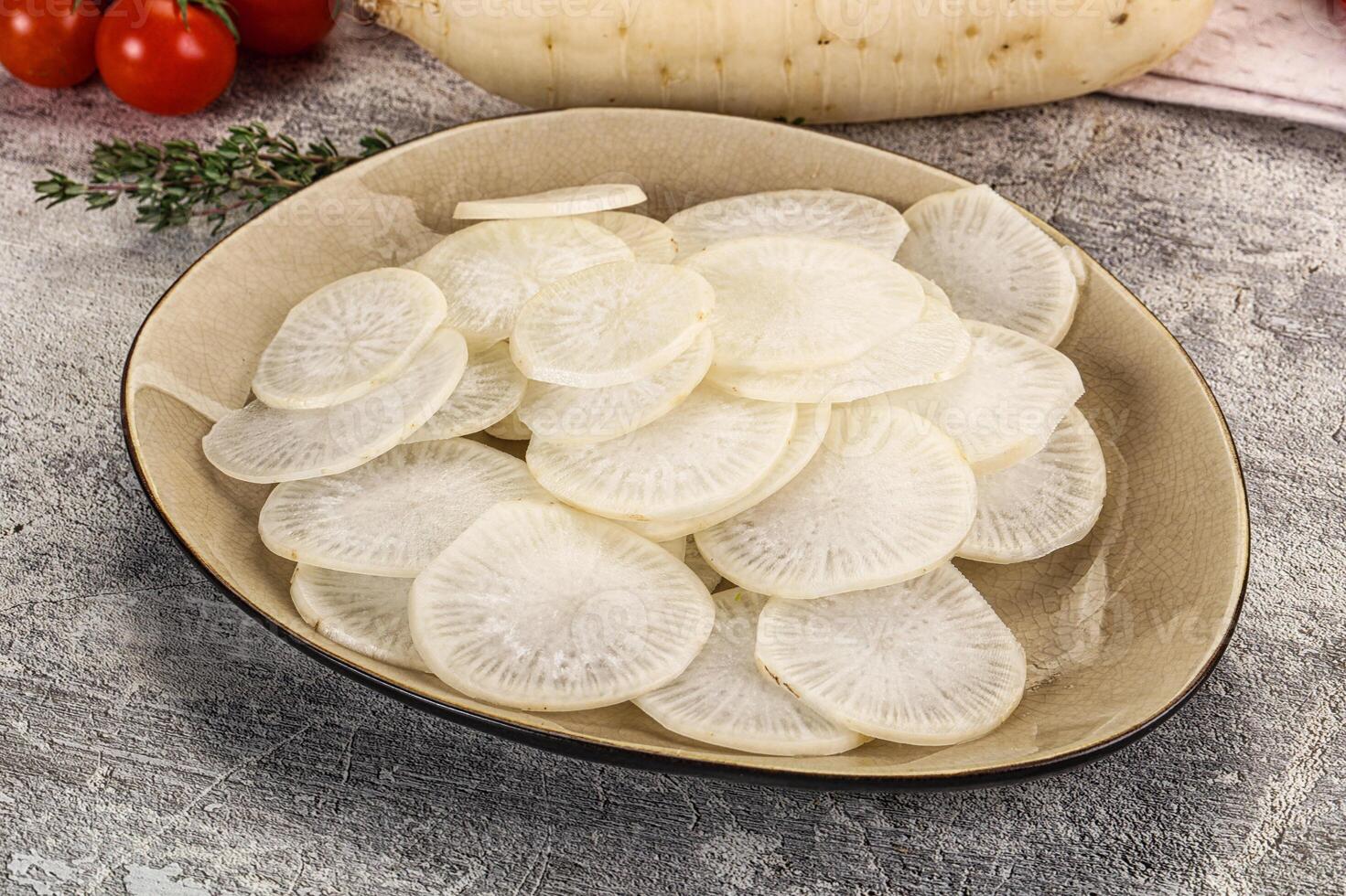 A bowl of sliced white radishes on a table photo