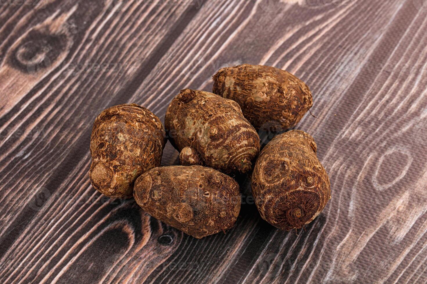 A pile of brown potatoes on a wooden table photo