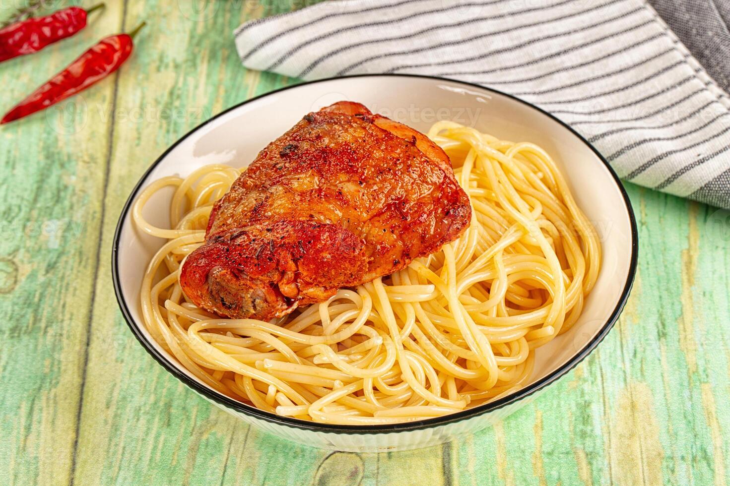 A bowl of pasta and a chicken leg photo