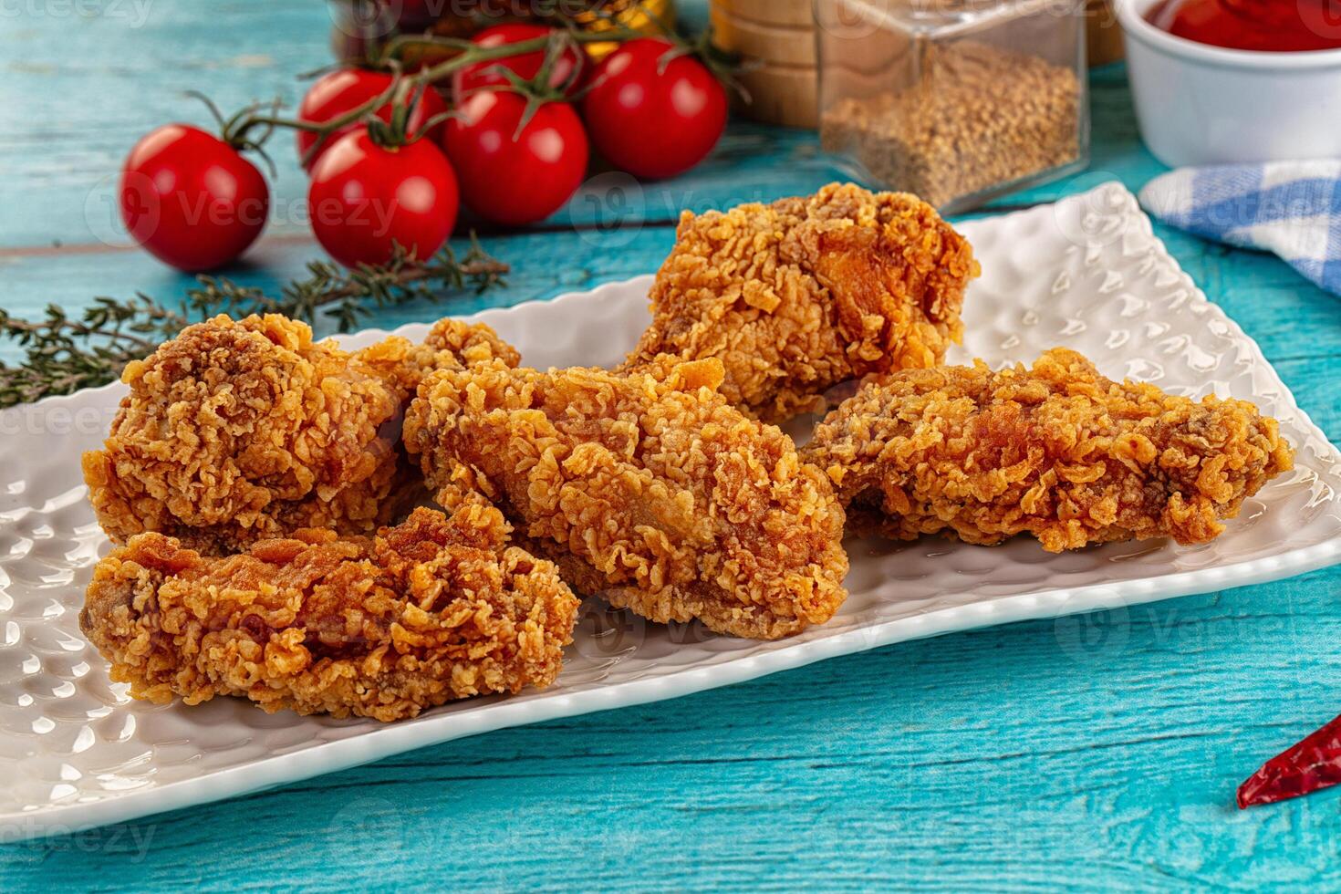 A plate of fried chicken on a blue table photo
