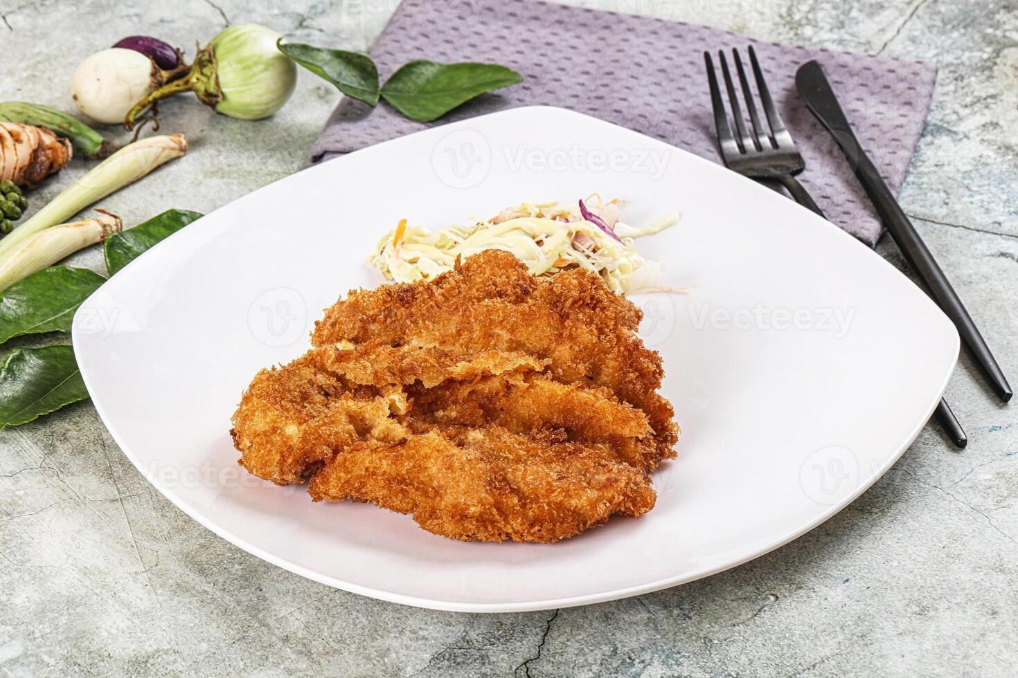 Fried chicken cutlet with coleslaw on white plate photo