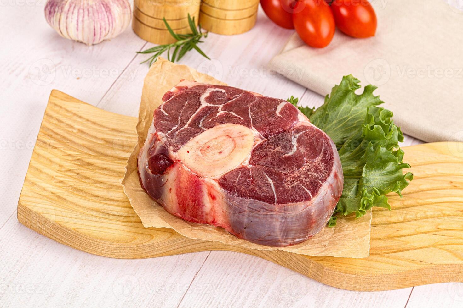 A piece of meat on a cutting board with vegetables photo