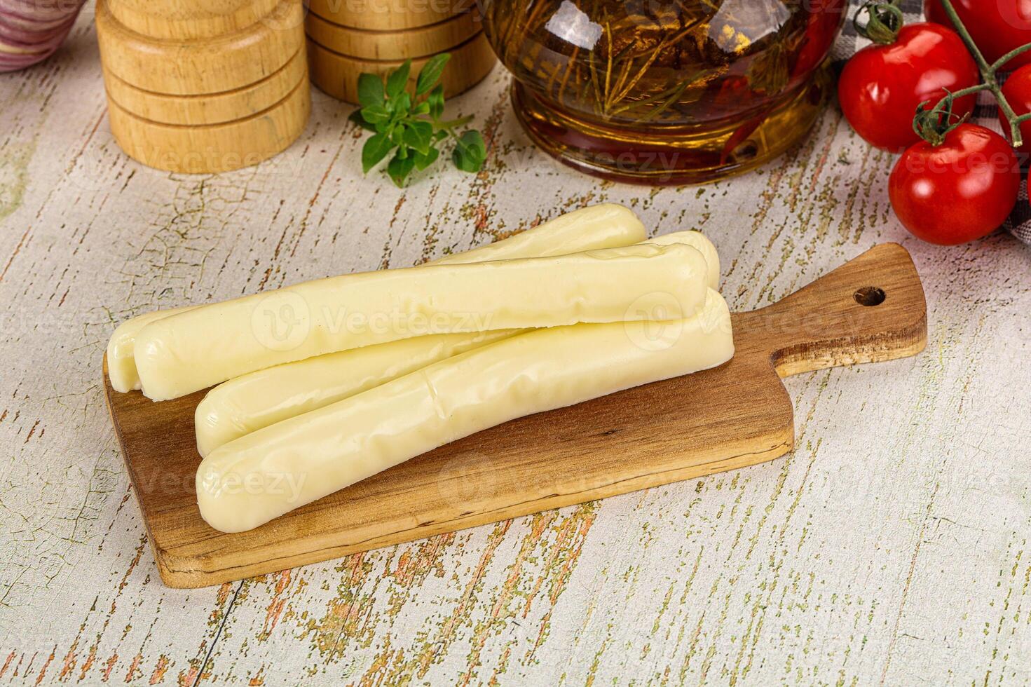 A wooden cutting board with cheese and other ingredients photo