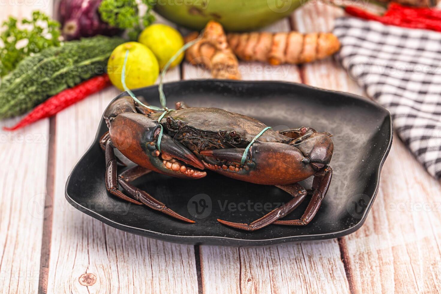 A crab on a plate with vegetables and spices photo