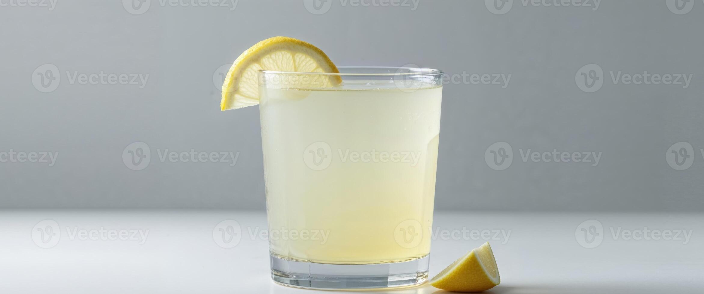 A glass of lemonade with a slice of lemon floating in it photo