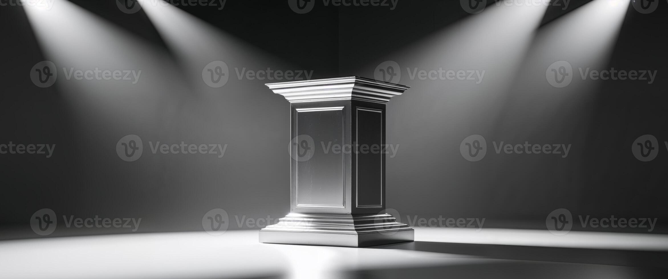 A silver pedestal sits in the center of a stage illuminated by spotlights photo