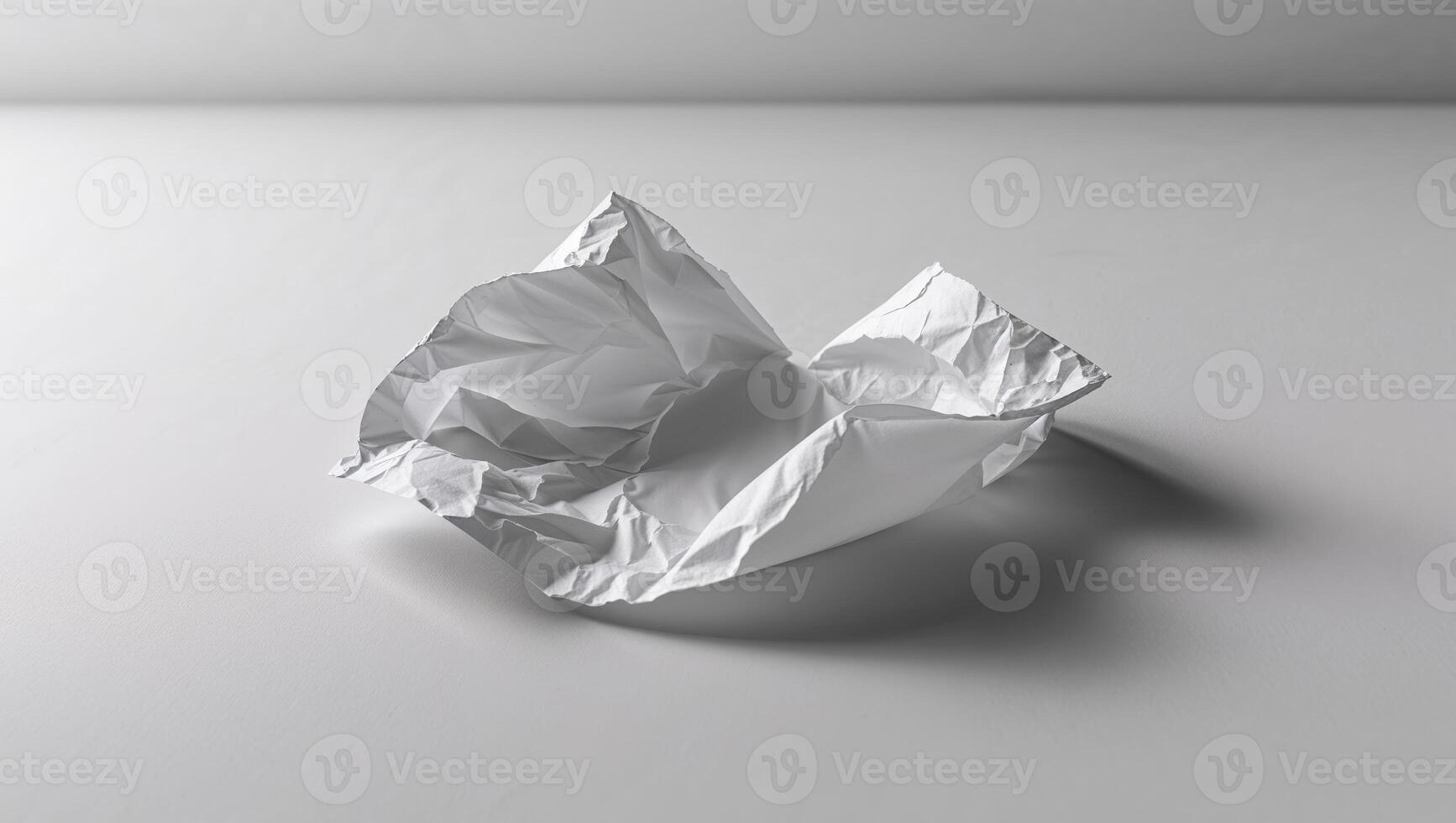 A crumpled piece of paper on a white surface photo