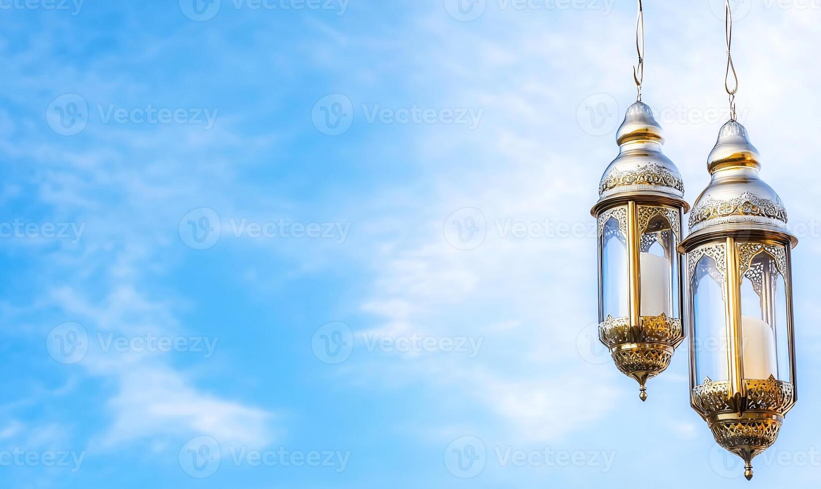 Two ornate lanterns hanging against a blue sky. photo