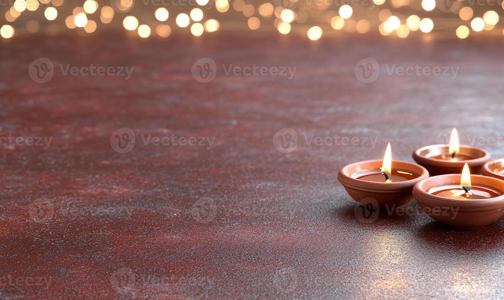 Four clay lamps with flickering flames on a textured surface. photo