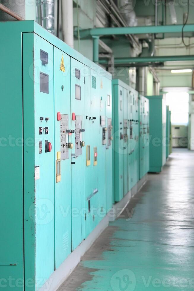 Industrial control panels in factory hallway photo