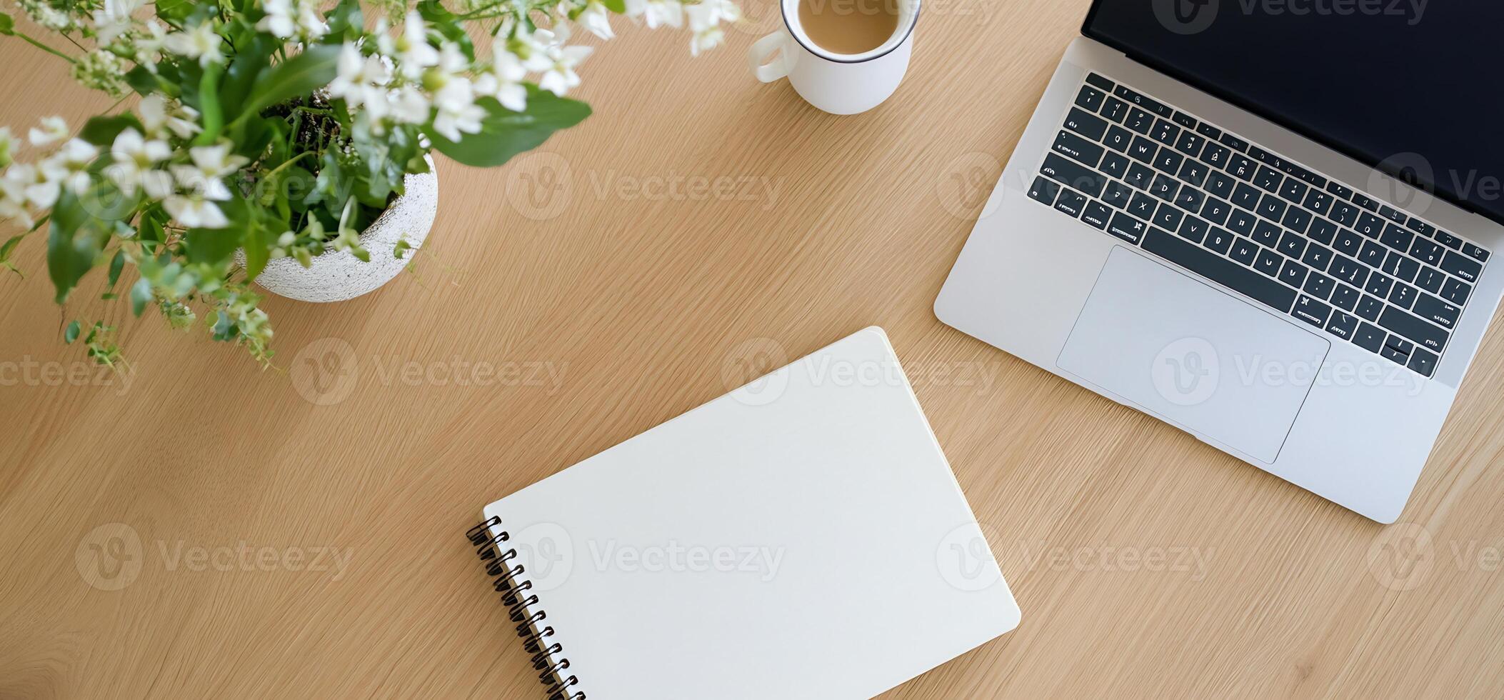 Wood desk, laptop, notebook, coffee, flowers. Work from home photo