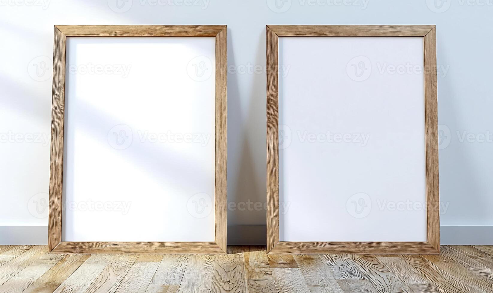 Two blank frames on light wood floor, sunlit wall. Mockup for design photo