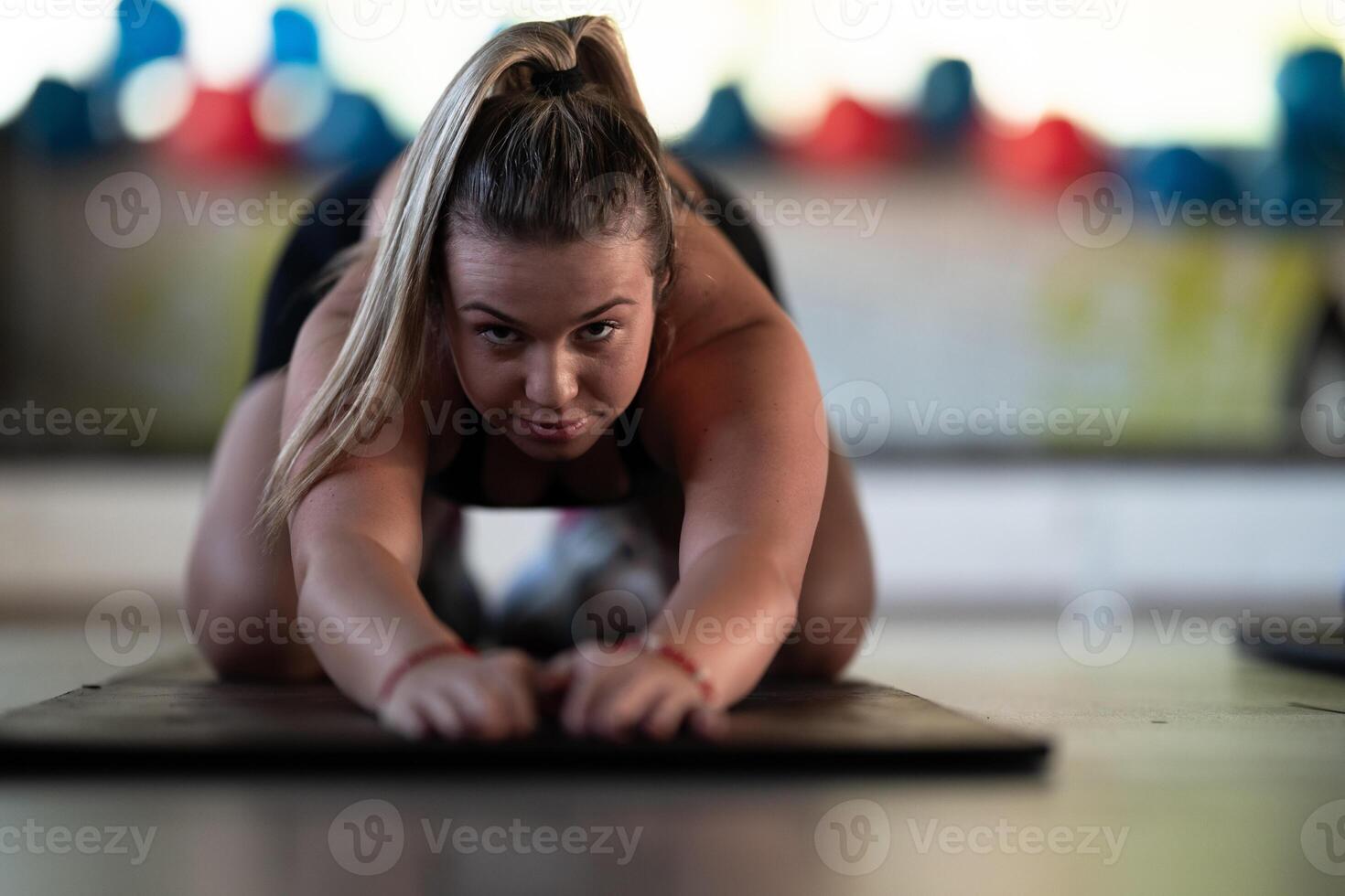 A woman stretches her body in the gym after an intense workout, a healthy muscle stretch after training. photo