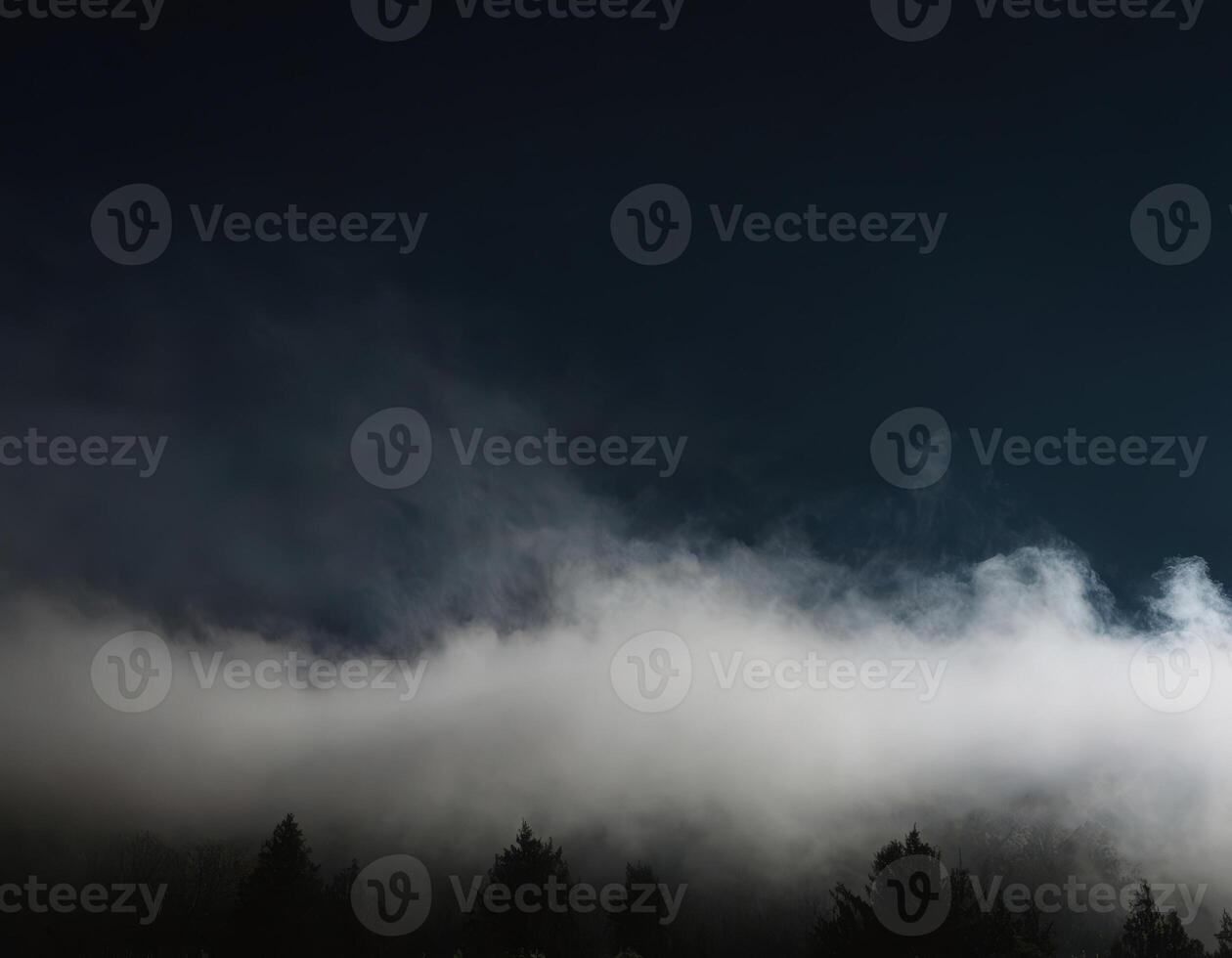 A full moon is seen over a forest with fog photo