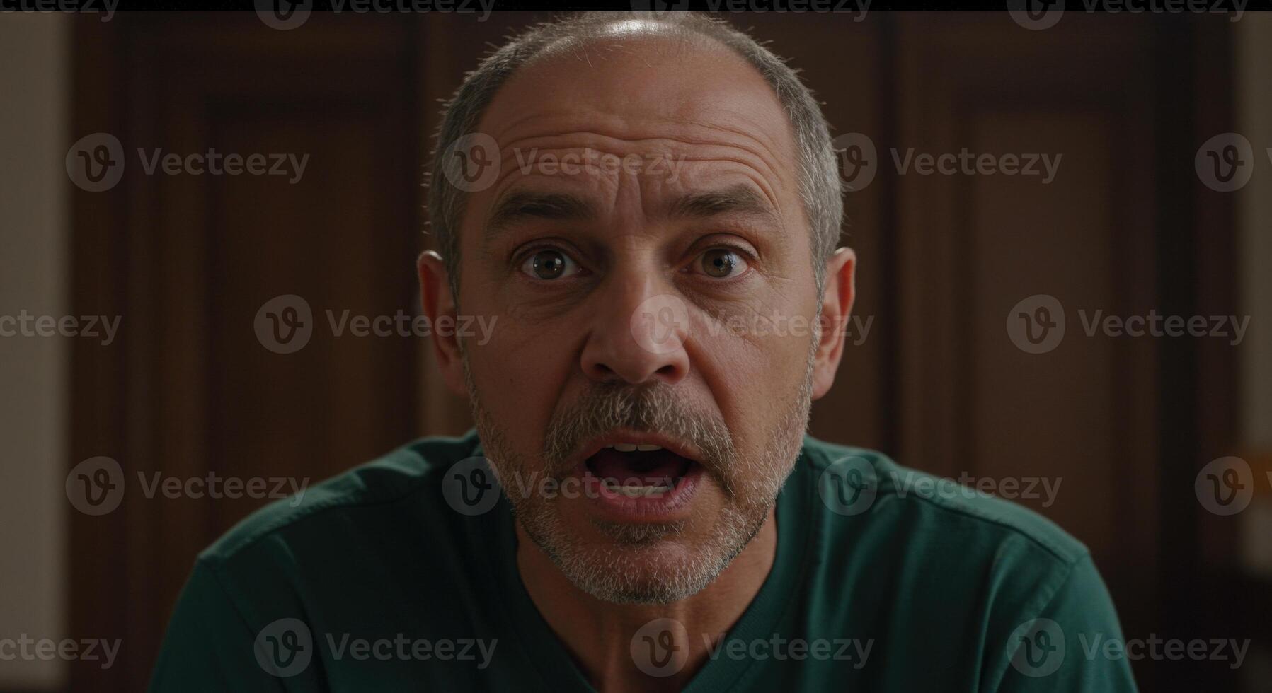 A man with a shocked expression in a green shirt photo