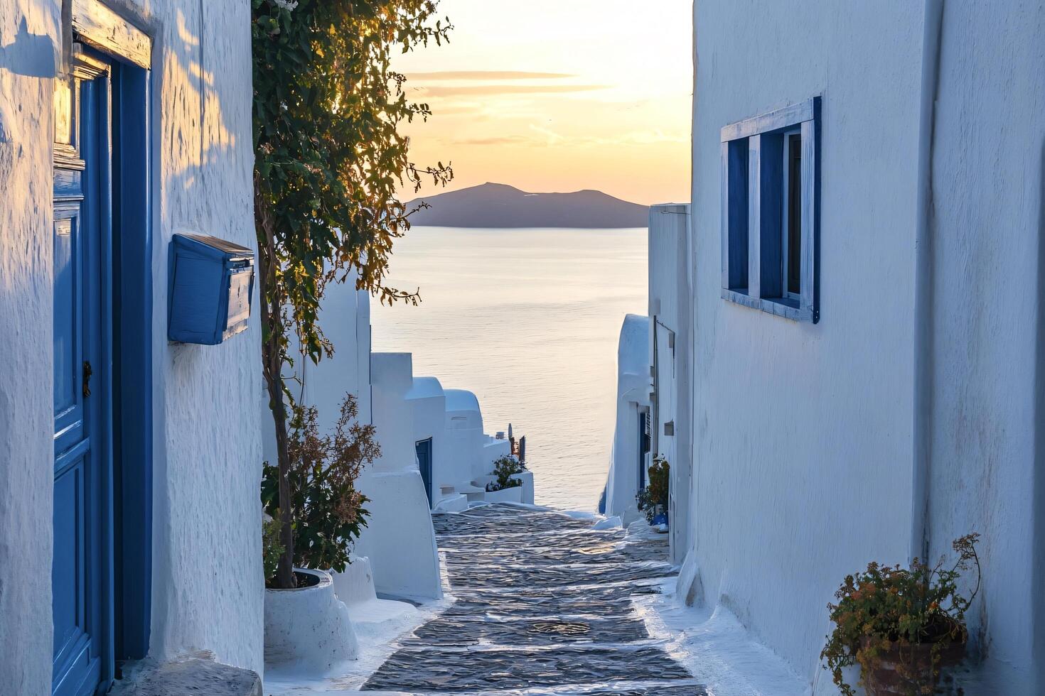Narrow street leading to the aegean sea at sunset photo