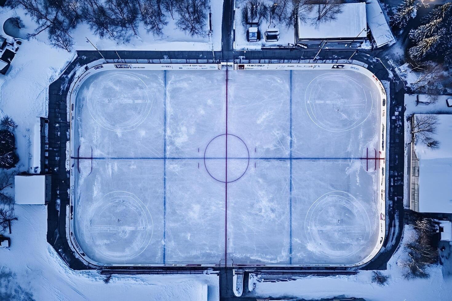 Empty outdoor ice hockey rink covered in snow in winter photo